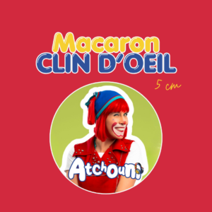 Macaron Atchoum « Clin d'œil » de 5 cm, badge rond sur fond vert avec une photo du personnage Atchoum souriante en veste rouge à clous et tuque bleue, sur fond rouge.